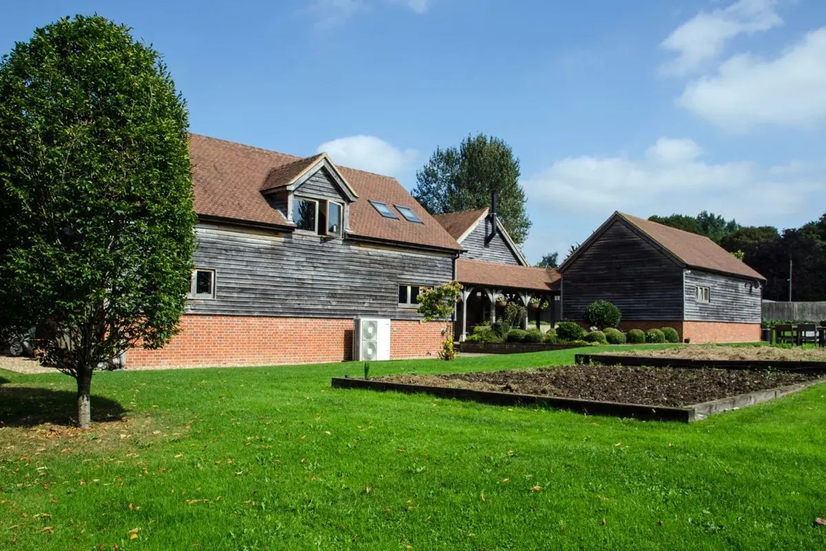 Black weatherboard barn conversion with lawn and gardens